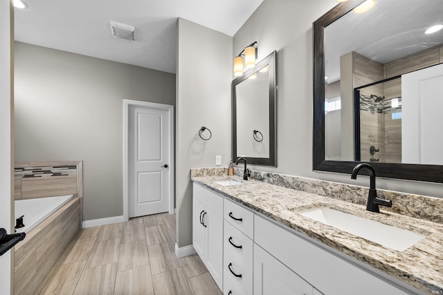 bathroom featuring vanity and shower with separate bathtub