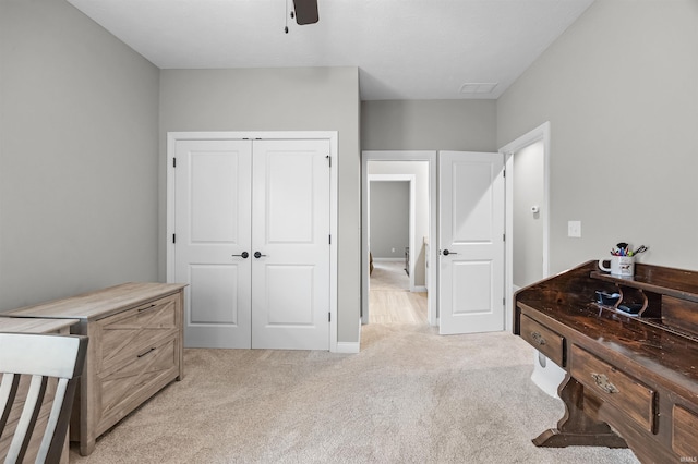 bedroom with light colored carpet, ceiling fan, and a closet