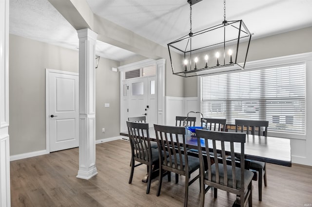 dining room featuring ornate columns and hardwood / wood-style floors