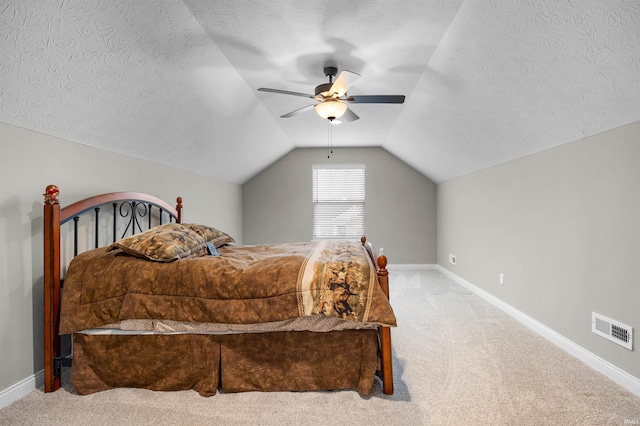 carpeted bedroom featuring vaulted ceiling, ceiling fan, and a textured ceiling