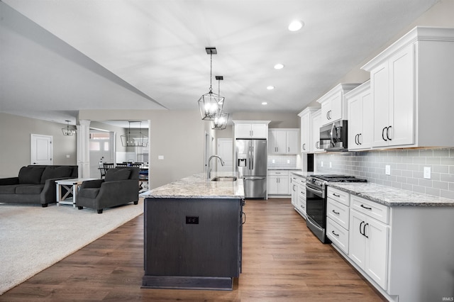 kitchen with sink, decorative light fixtures, a center island with sink, appliances with stainless steel finishes, and white cabinets