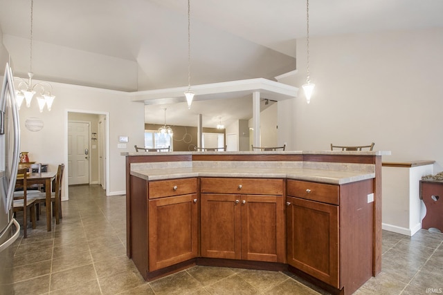 kitchen with hanging light fixtures, vaulted ceiling, a kitchen island, and a notable chandelier