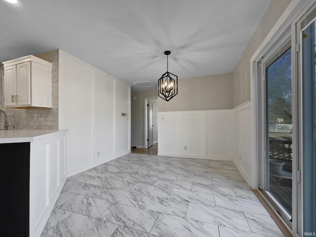 unfurnished dining area with a notable chandelier and sink