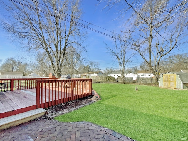 view of yard featuring a wooden deck and a storage unit