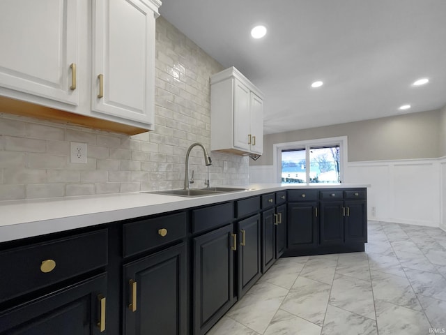 kitchen featuring white cabinetry, sink, and tasteful backsplash