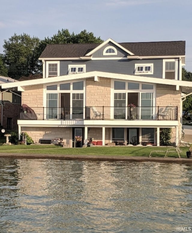 rear view of house with a water view and a balcony