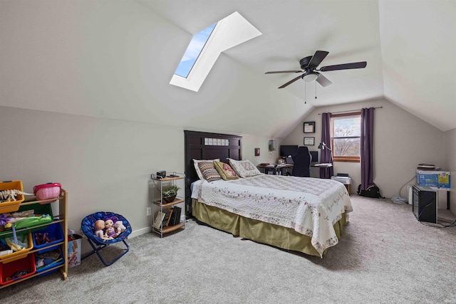 carpeted bedroom featuring vaulted ceiling with skylight and ceiling fan