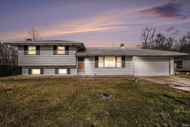 split level home with a garage and a lawn