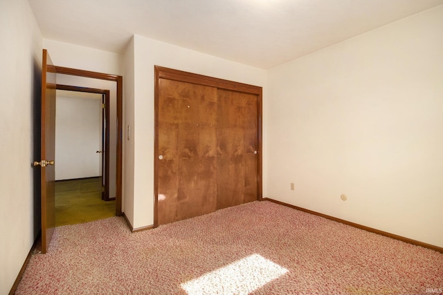 unfurnished bedroom featuring light colored carpet and a closet