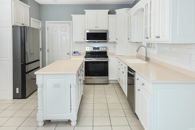 kitchen featuring sink, a kitchen island, white cabinets, and appliances with stainless steel finishes