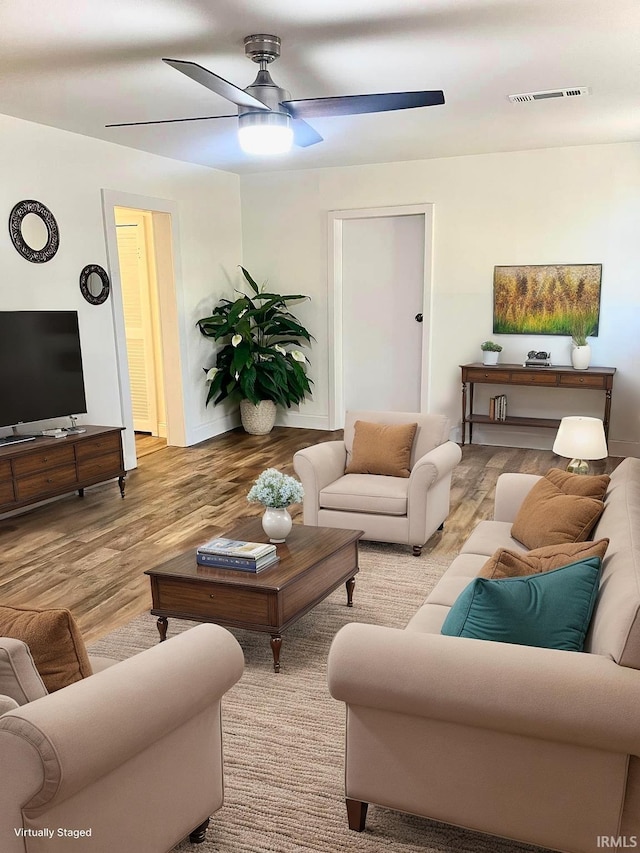 living room featuring light hardwood / wood-style floors and ceiling fan