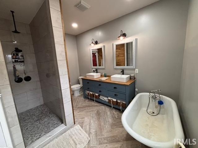 full bathroom with independent shower and bath, vanity, parquet floors, and toilet