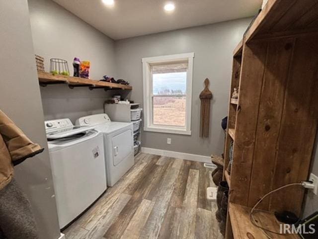 clothes washing area with independent washer and dryer and hardwood / wood-style floors