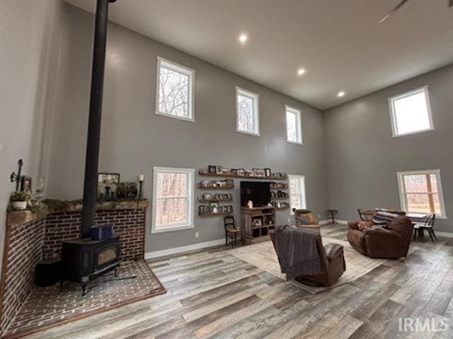 living room with a healthy amount of sunlight, a wood stove, and light hardwood / wood-style floors