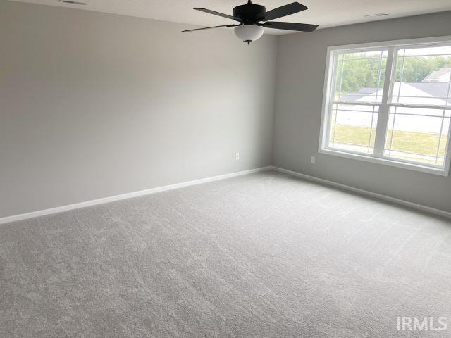 spare room featuring light colored carpet and ceiling fan