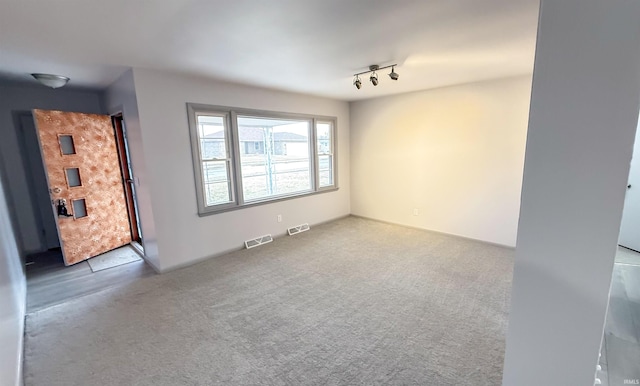 carpeted spare room with track lighting