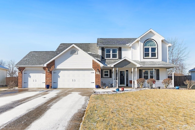 view of front of property with a garage, covered porch, and a front lawn