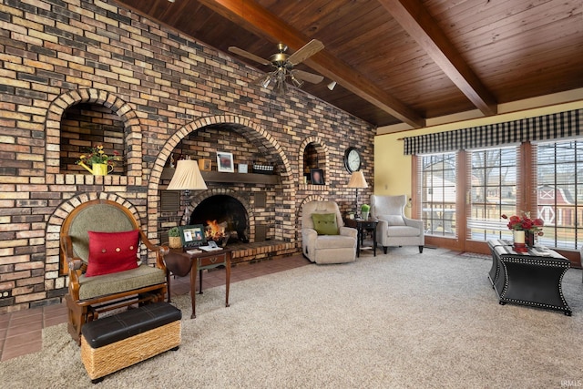 carpeted living room with vaulted ceiling with beams, wooden ceiling, ceiling fan, brick wall, and a fireplace