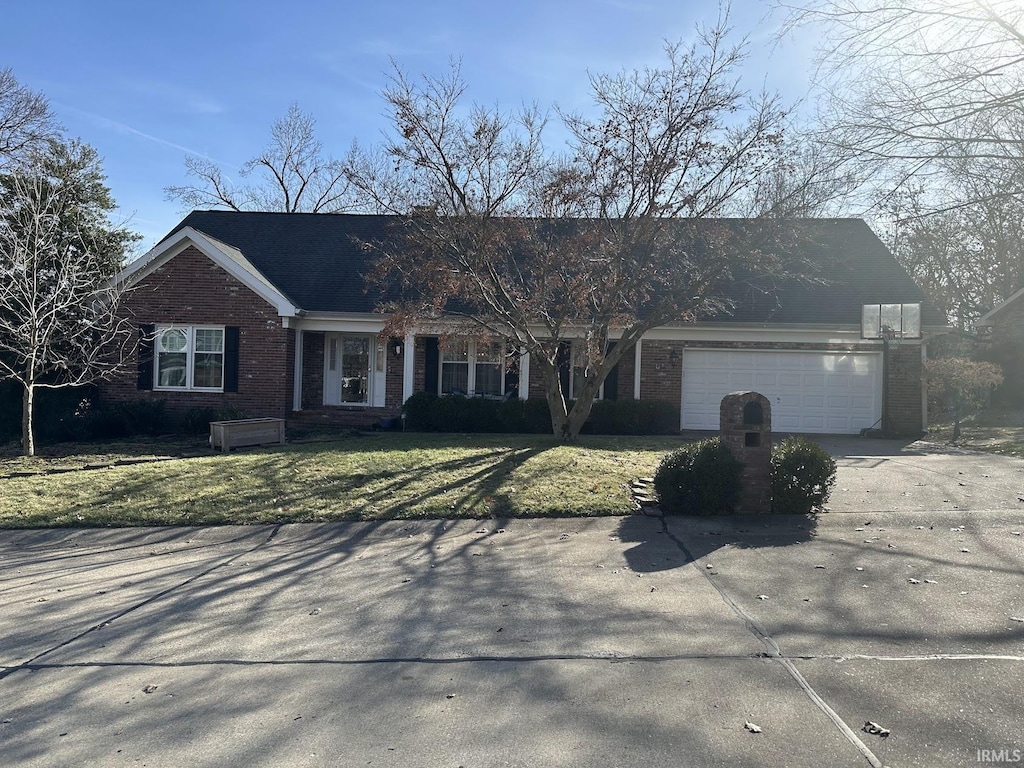 view of front facade with a garage, brick siding, driveway, and a front lawn