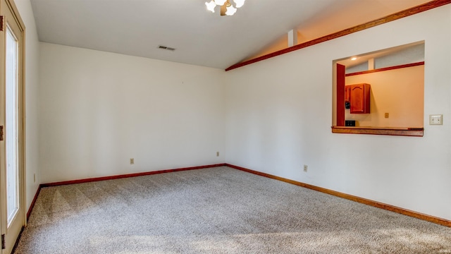 carpeted empty room featuring lofted ceiling