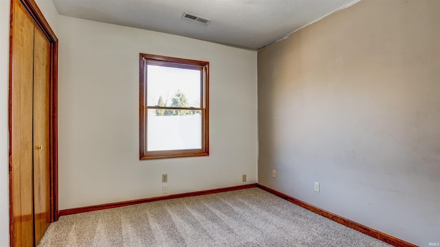 interior space featuring a closet, carpet flooring, and a textured ceiling