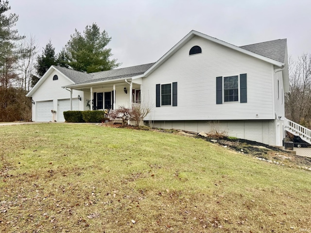 view of front of home with a garage, covered porch, and a front lawn