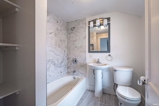 bathroom featuring tiled shower / bath combo and toilet