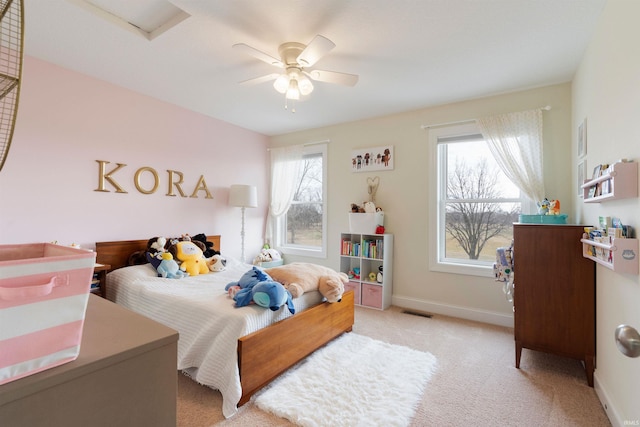 bedroom with ceiling fan, light colored carpet, and multiple windows