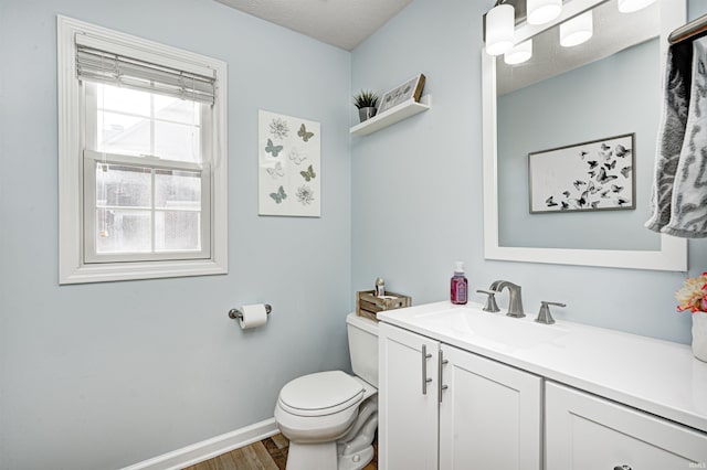 bathroom featuring vanity, wood-type flooring, a textured ceiling, and toilet