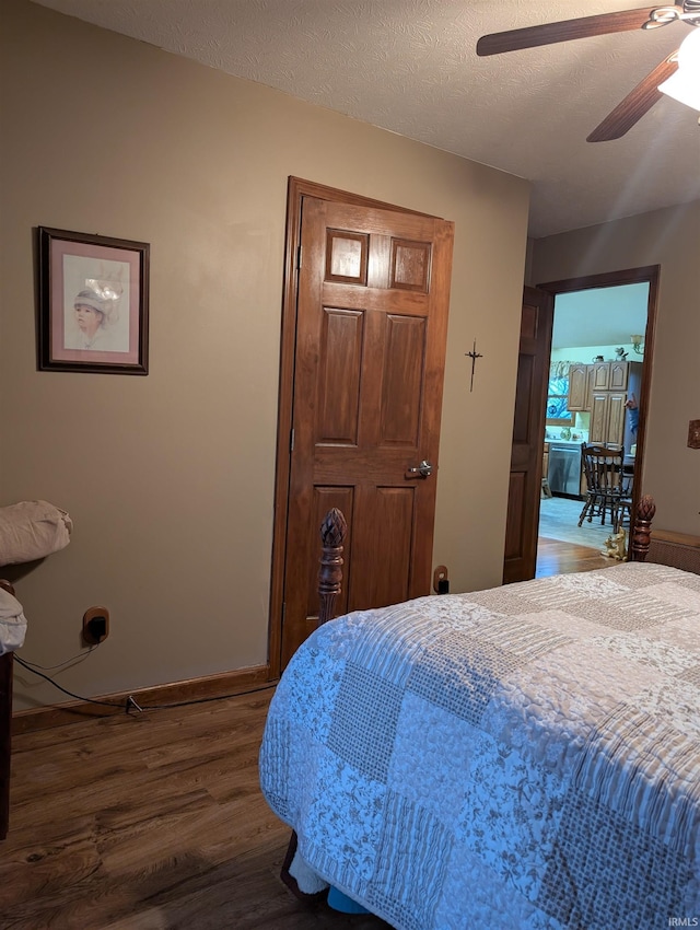 bedroom featuring ceiling fan, dark wood-type flooring, and a textured ceiling