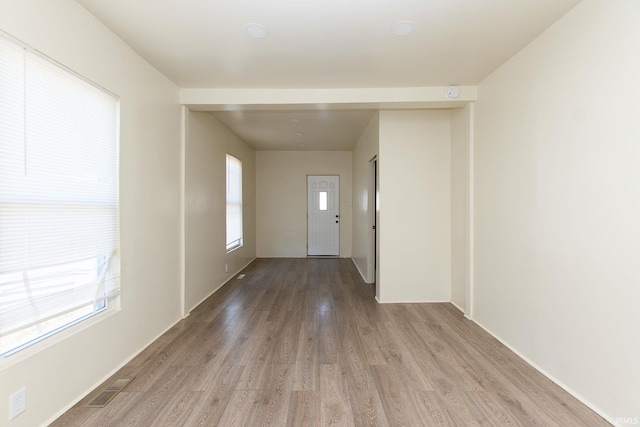 unfurnished room featuring a wealth of natural light and hardwood / wood-style floors