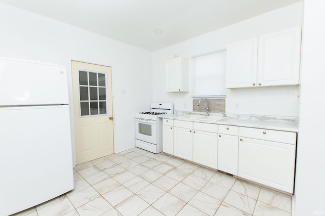 kitchen with sink, light stone counters, white cabinets, and white appliances