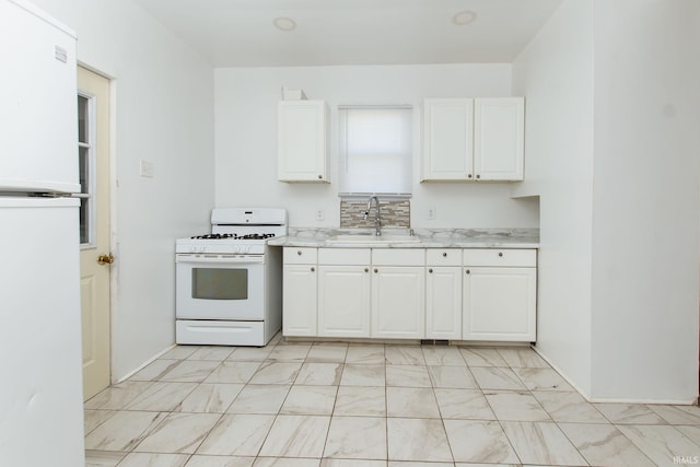 kitchen with white appliances, sink, and white cabinets