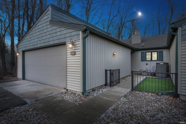 view of side of home featuring a garage and central AC