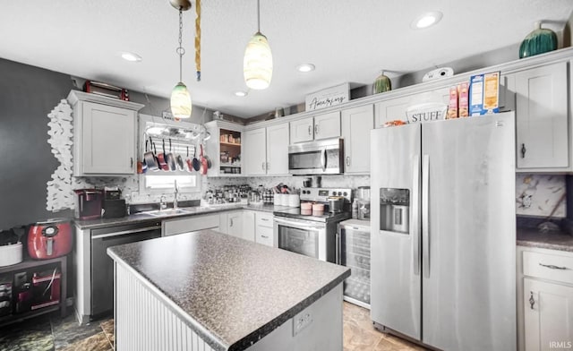 kitchen featuring sink, backsplash, hanging light fixtures, a center island, and stainless steel appliances