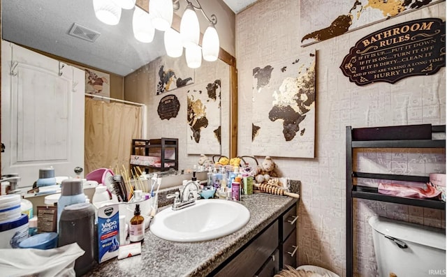 bathroom featuring vanity, a textured ceiling, toilet, and a shower with shower curtain