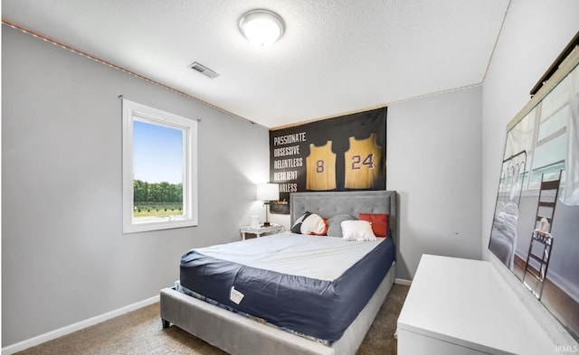 bedroom featuring dark carpet and a textured ceiling