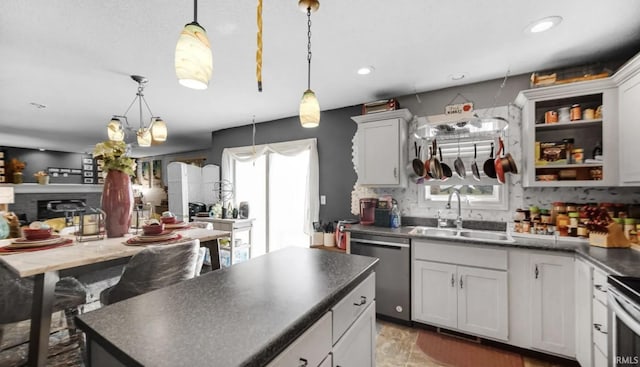 kitchen with sink, a center island, appliances with stainless steel finishes, pendant lighting, and white cabinets