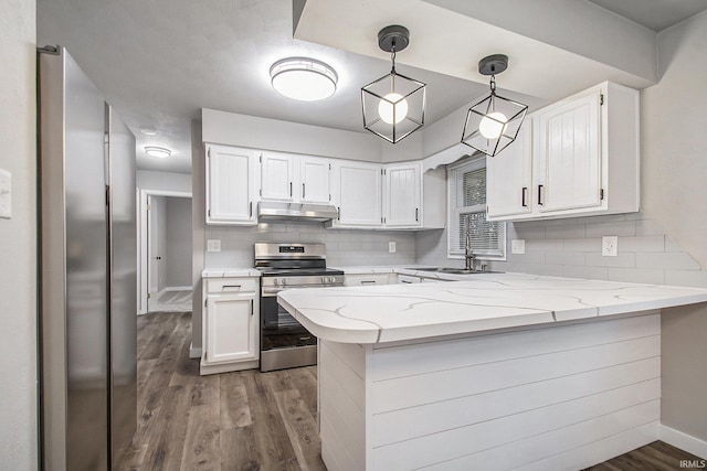 kitchen with appliances with stainless steel finishes, white cabinetry, sink, hanging light fixtures, and kitchen peninsula