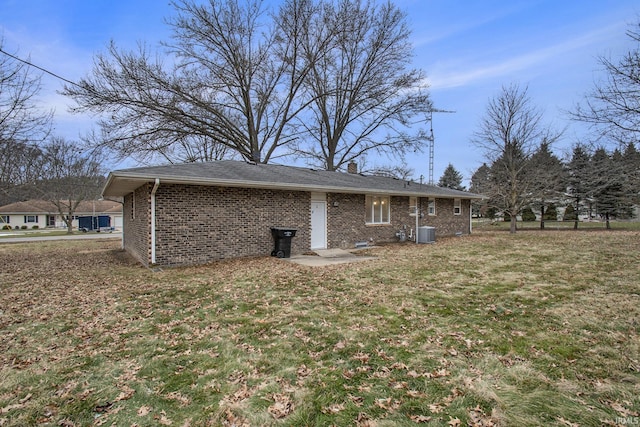 rear view of house featuring central AC and a lawn