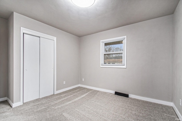 unfurnished bedroom with carpet flooring and a closet