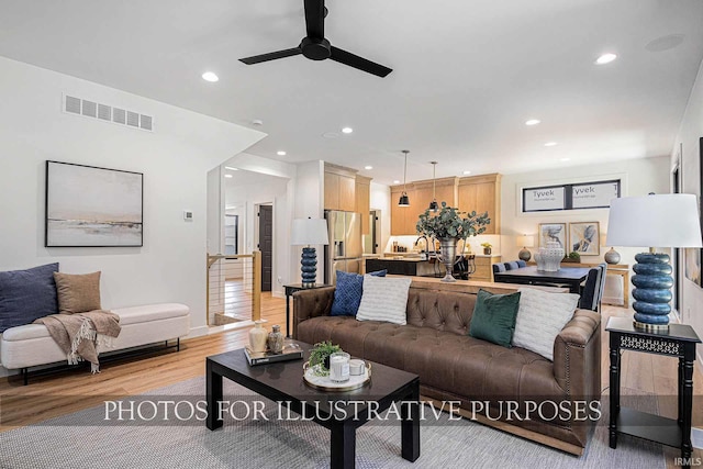 living room with ceiling fan and light hardwood / wood-style flooring