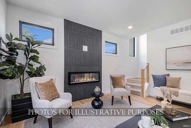 living room featuring a large fireplace and light hardwood / wood-style flooring