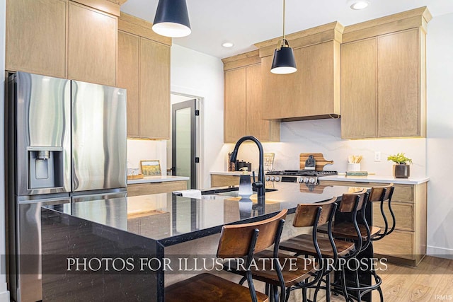 kitchen featuring pendant lighting, light brown cabinets, stainless steel fridge with ice dispenser, decorative backsplash, and light wood-type flooring