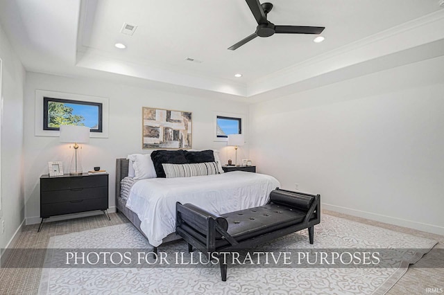 bedroom with ceiling fan and a tray ceiling