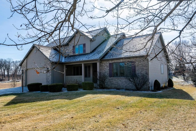 view of front of home with a garage, a front yard, and covered porch