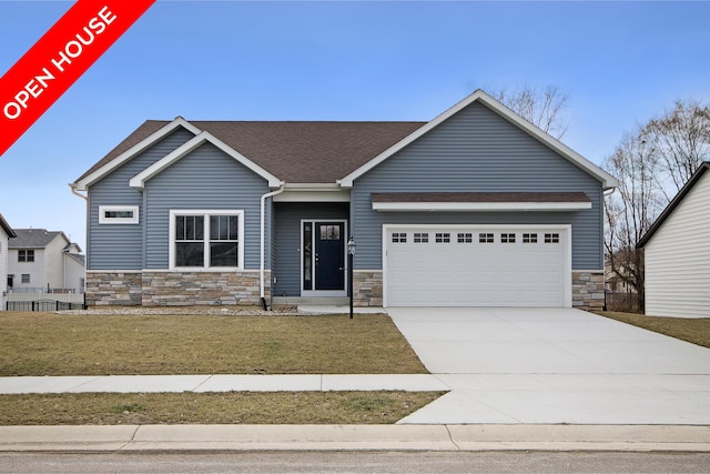 craftsman inspired home featuring a garage and a front lawn