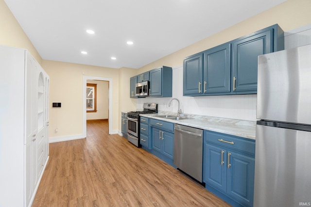 kitchen featuring stainless steel appliances, sink, and blue cabinets