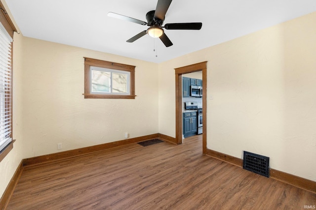 spare room with ceiling fan and dark hardwood / wood-style floors