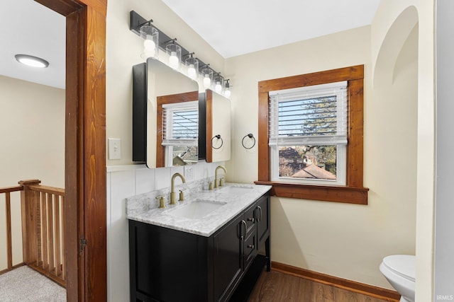 bathroom featuring vanity, toilet, hardwood / wood-style floors, and a wealth of natural light